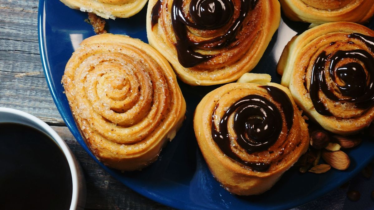 Chocolate Covered Cinnamon Rolls Served Next to a Cup of Coffee