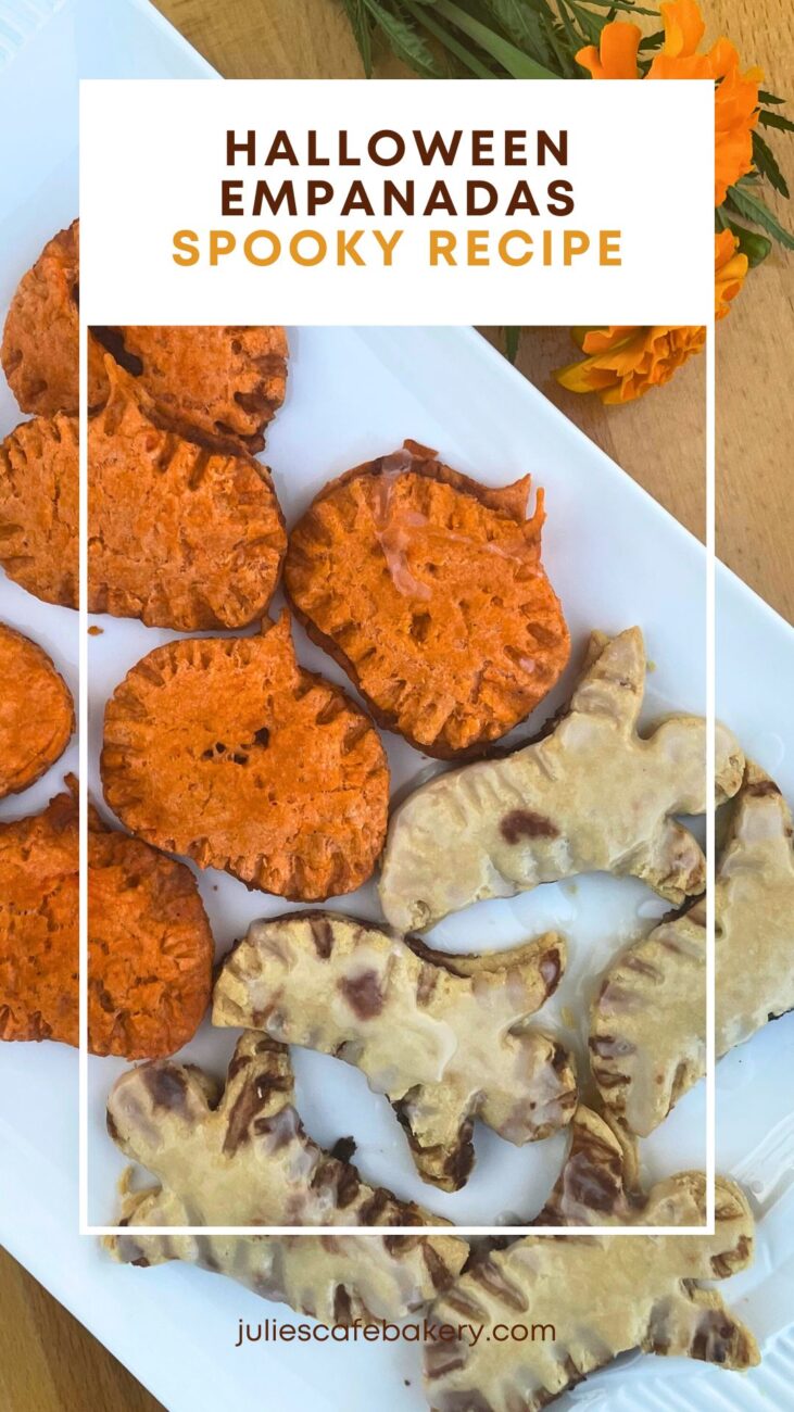 Halloween empanadas shaped like pumpkins and bloody ghosts served on a white plate next to a carnation flower bouquet