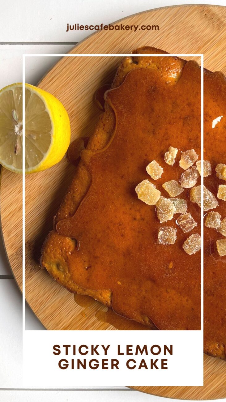 sticky lemon ginger cake served on a wooden board on a white table next to a halved lemon