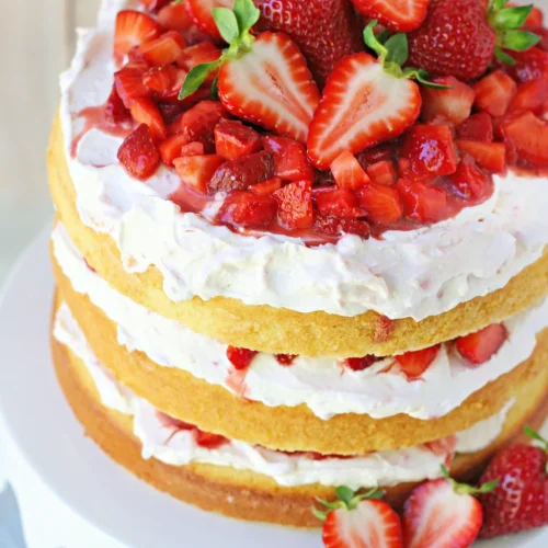 top down view of strawberry shortcake cake on white metal cake stand